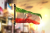 عکس با کیفیت پرچم درحال اهتزاز ایران با زمینه نارنجی و غروب خورشید